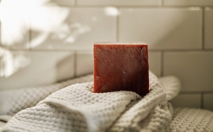 Savon artisanal sur une serviette illustrant le retour aux soins simples